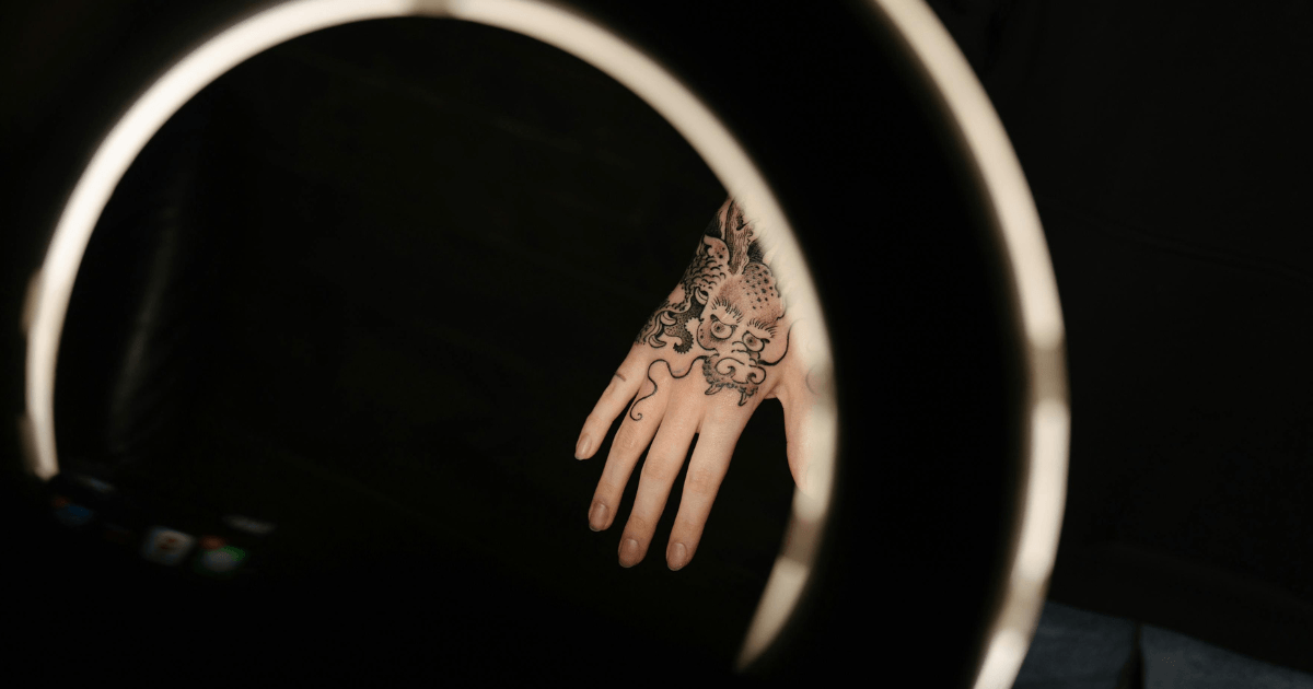 A close-up of a person's hands adorned with intricate tattoos, showcasing detailed designs and vibrant colors.